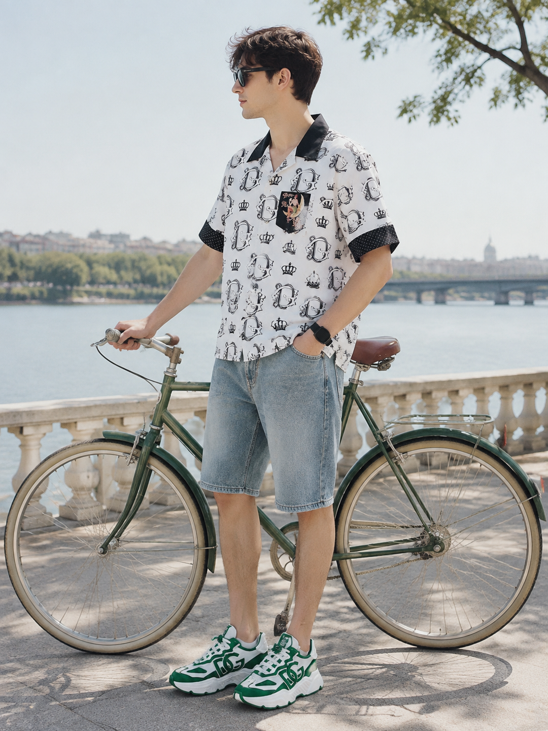 Men's white patterned shirt, blue denim shorts and green sneakers beside a bicycle