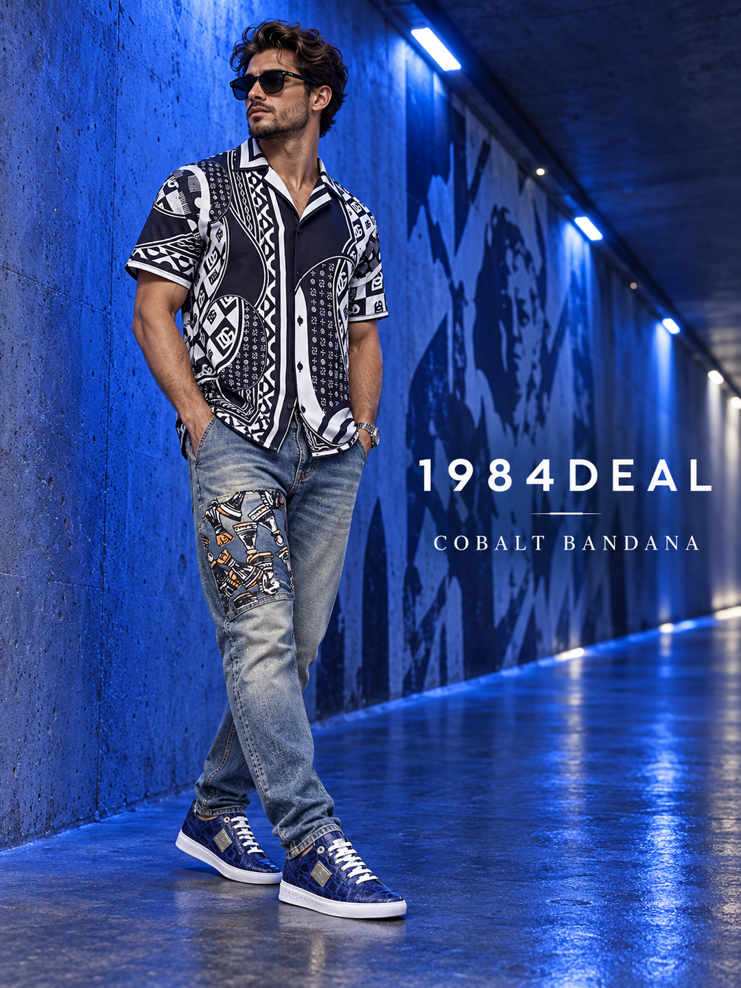 Adult male in a black-white bandana print shirt, faded gray-blue jeans and cobalt-blue sneakers