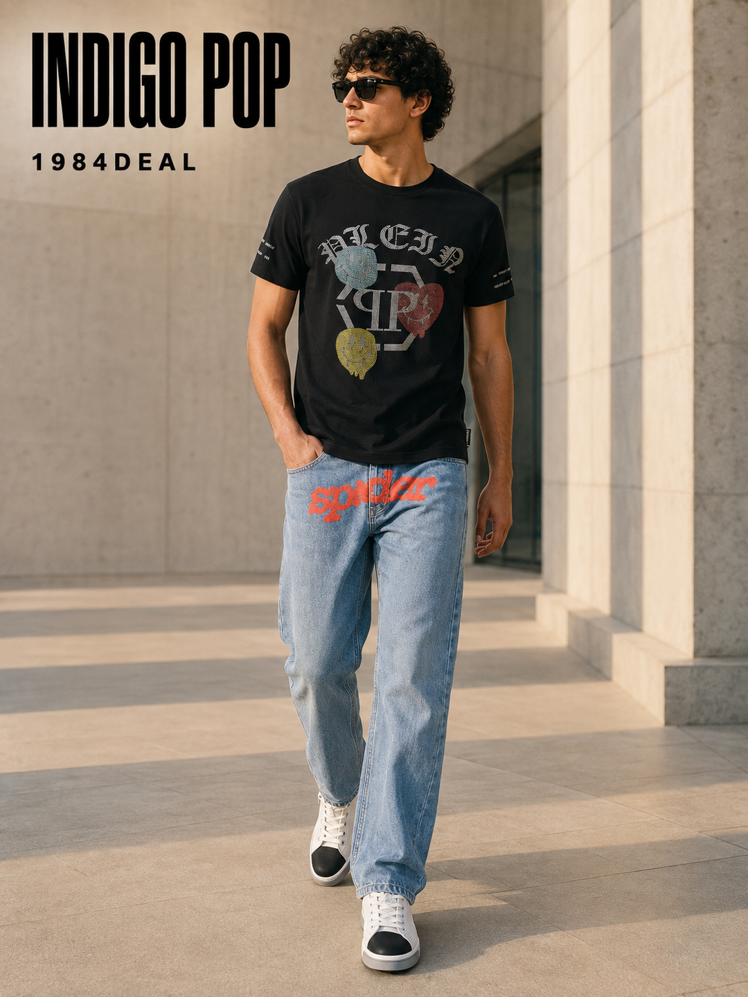 Man wearing a black multicolor graphic T-shirt, light indigo jeans and white-black sneakers
