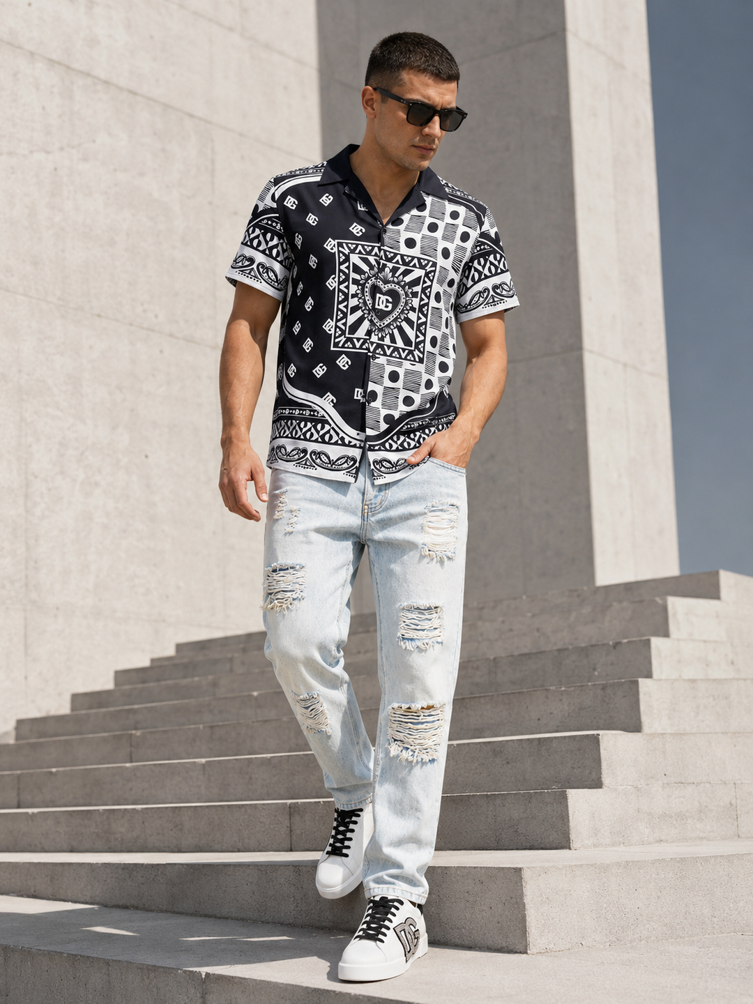 Male model wearing a black-white printed shirt, light ripped jeans and white-gold sneakers